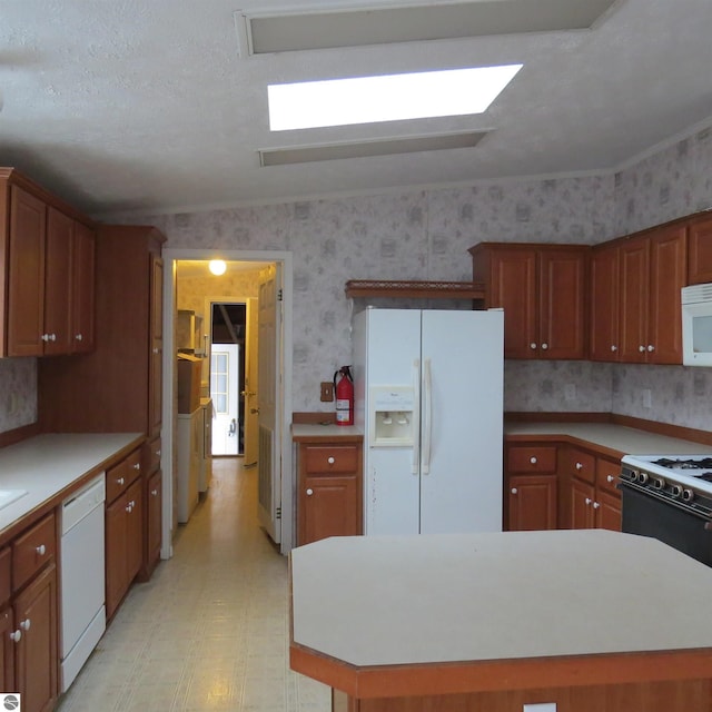 kitchen featuring a center island, white appliances, and a textured ceiling