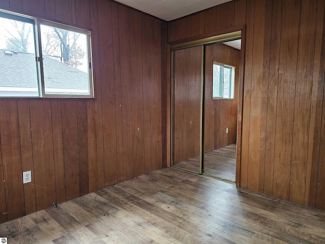 empty room with wood walls and hardwood / wood-style floors