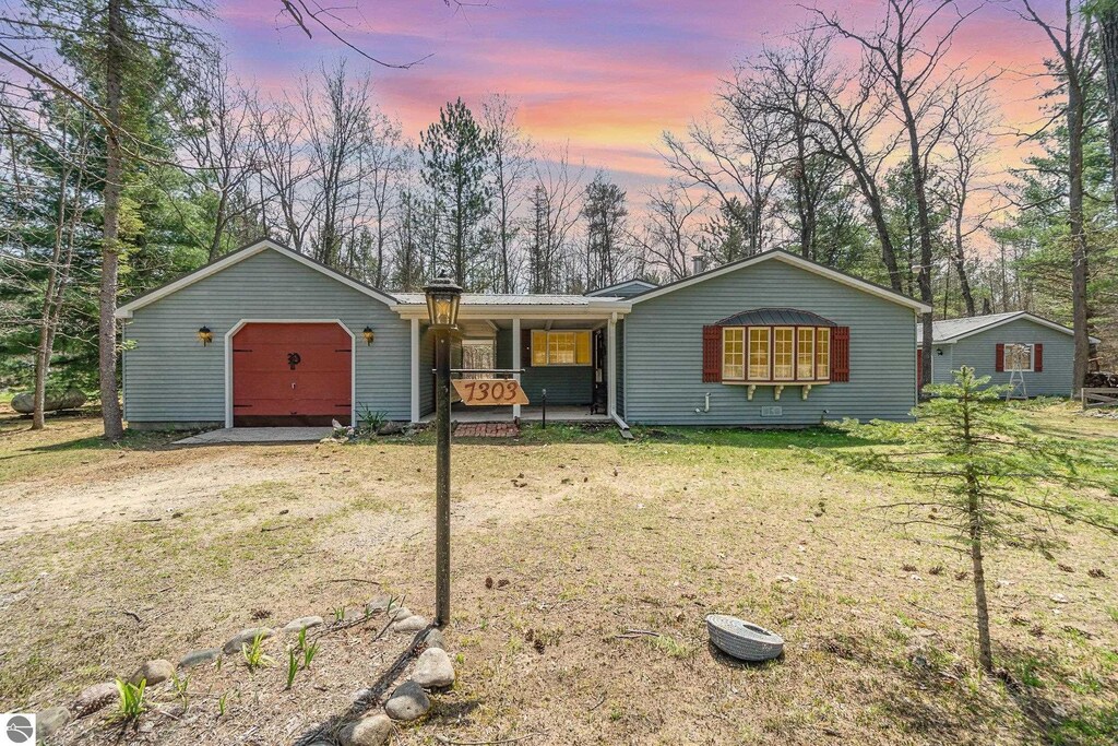 ranch-style home featuring a yard and covered porch