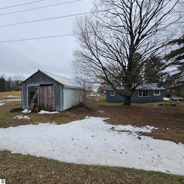 yard layered in snow featuring an outdoor structure