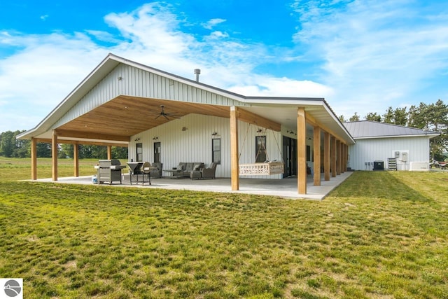 rear view of property with ceiling fan, a patio area, and a yard