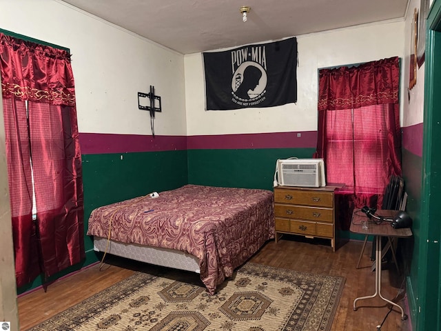 bedroom with a wall unit AC and hardwood / wood-style flooring