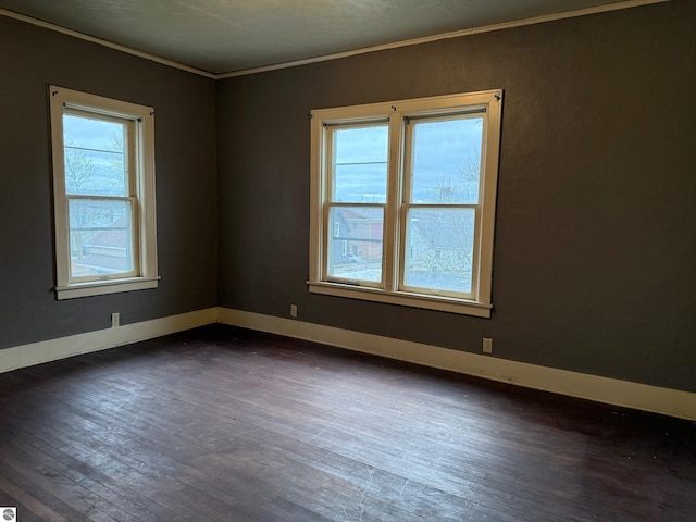 unfurnished room featuring dark hardwood / wood-style floors, ornamental molding, and a wealth of natural light