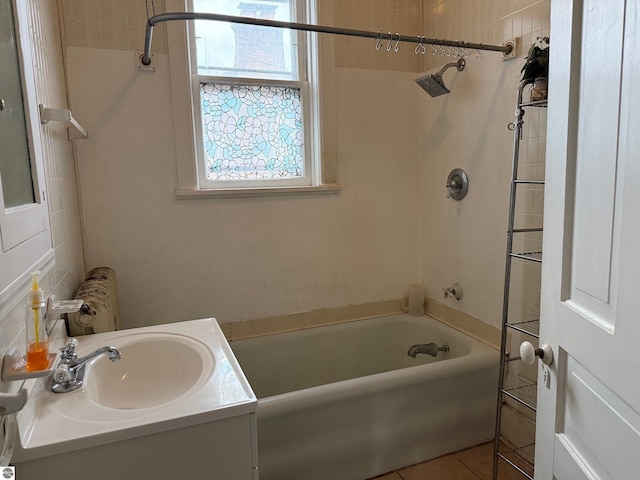 bathroom featuring tile patterned flooring, vanity, and tiled shower / bath