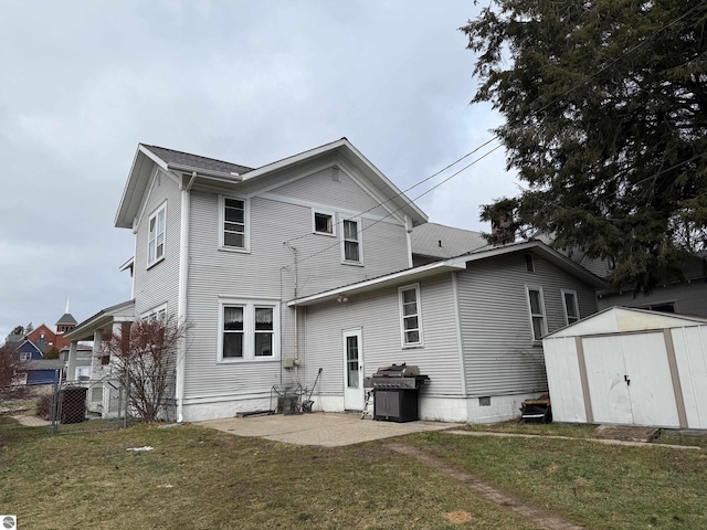 rear view of house with a lawn and a storage unit