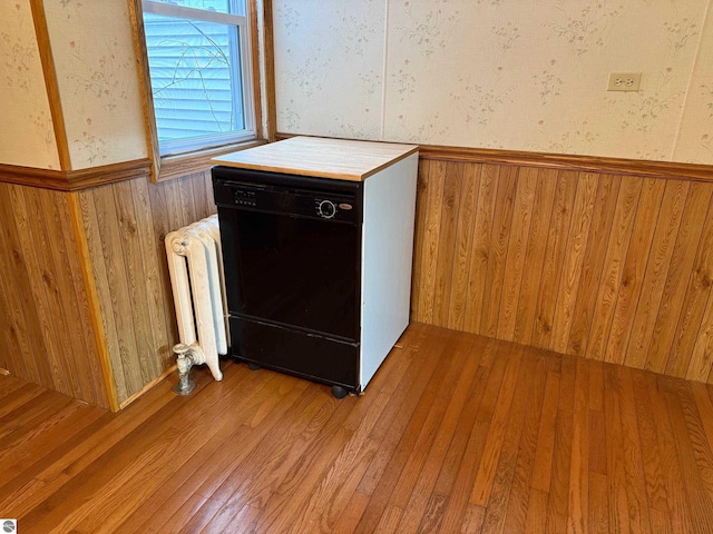 details with dishwasher, hardwood / wood-style flooring, and radiator