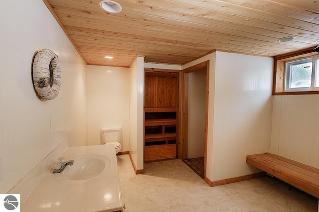 bathroom with vanity, wood walls, toilet, and wooden ceiling