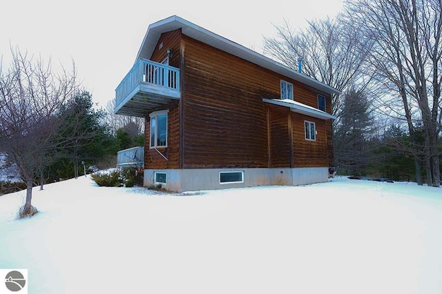 snow covered property featuring a balcony