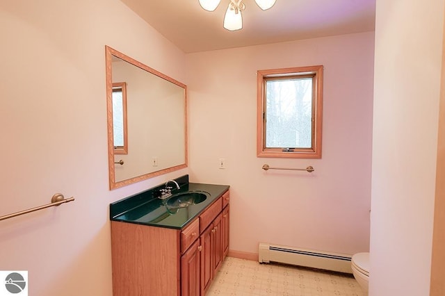 bathroom with vanity, toilet, and a baseboard heating unit