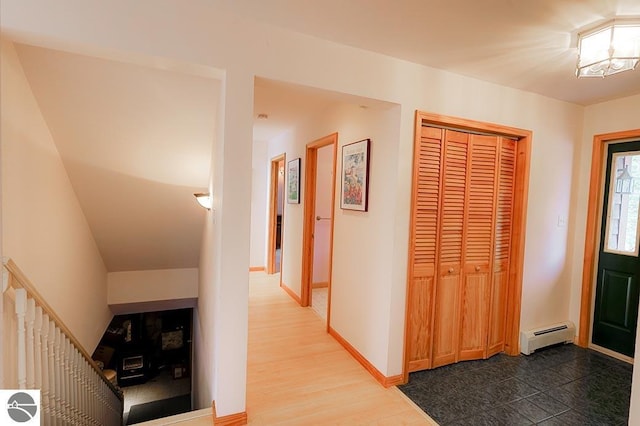 corridor with wood-type flooring, an inviting chandelier, and a baseboard heating unit