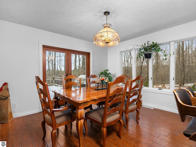 dining space with french doors, dark hardwood / wood-style floors, and a notable chandelier