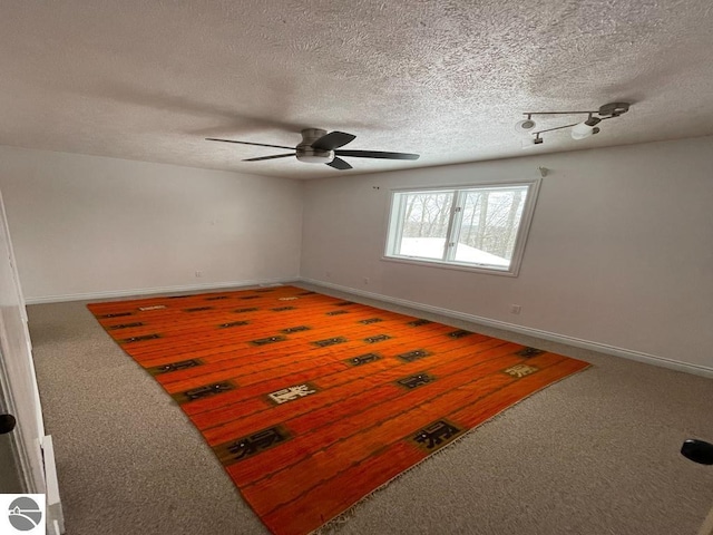 carpeted empty room with ceiling fan and a textured ceiling