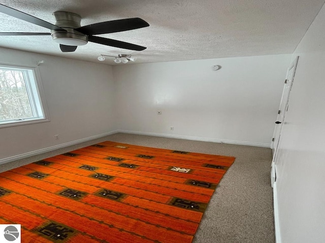 unfurnished room featuring carpet, ceiling fan, and a textured ceiling