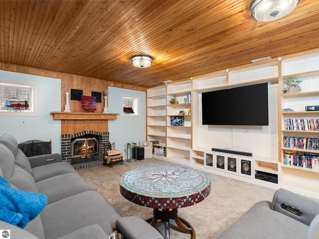 carpeted living room with built in shelves, a brick fireplace, wooden ceiling, and wood walls