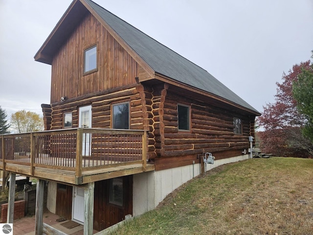 view of property exterior with a lawn and a deck