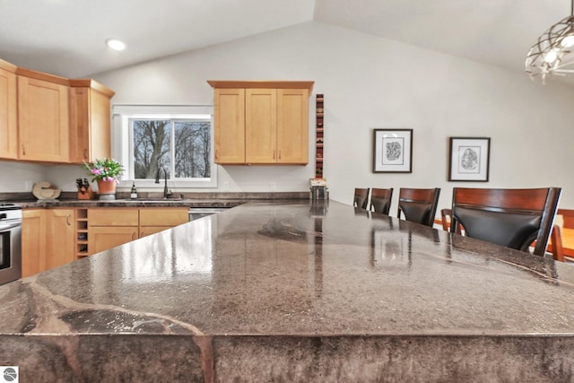 kitchen with a kitchen breakfast bar, light brown cabinets, hanging light fixtures, and lofted ceiling