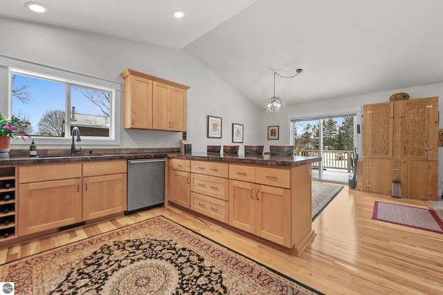 kitchen featuring sink, light hardwood / wood-style flooring, stainless steel dishwasher, pendant lighting, and lofted ceiling