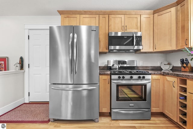 kitchen featuring light brown cabinets, a textured ceiling, and appliances with stainless steel finishes