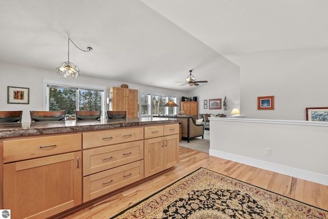 kitchen with ceiling fan, pendant lighting, light hardwood / wood-style floors, vaulted ceiling, and light brown cabinetry