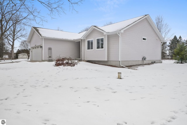 view of snow covered exterior with a garage