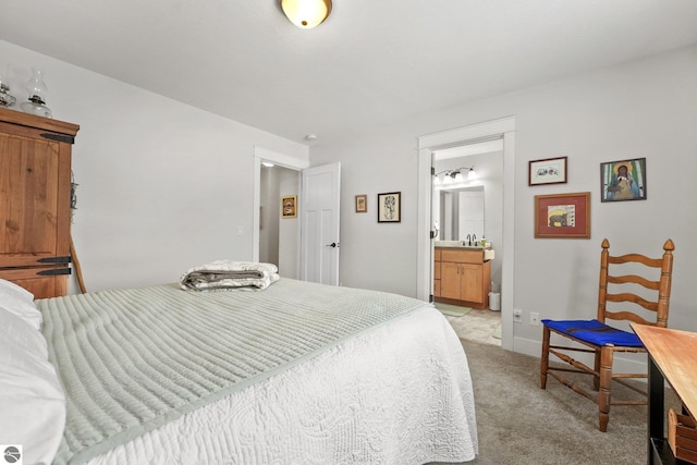 bedroom featuring sink, light colored carpet, and ensuite bathroom