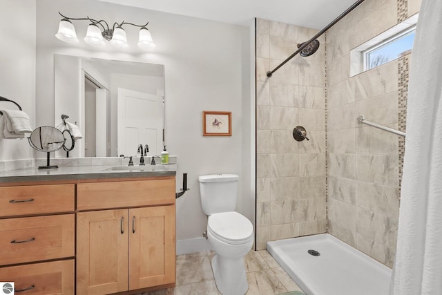 bathroom with tile patterned floors, vanity, toilet, and tiled shower