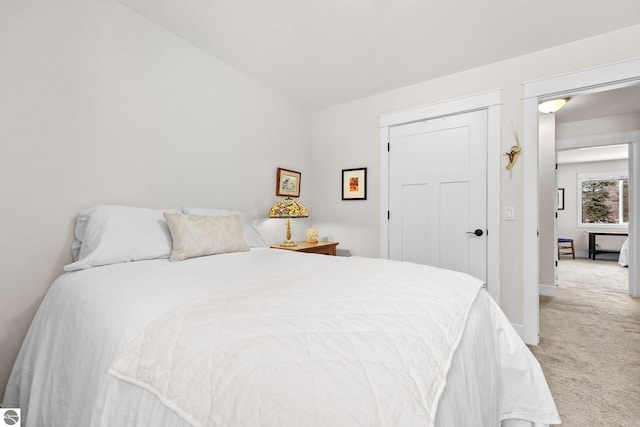 carpeted bedroom featuring a closet and vaulted ceiling