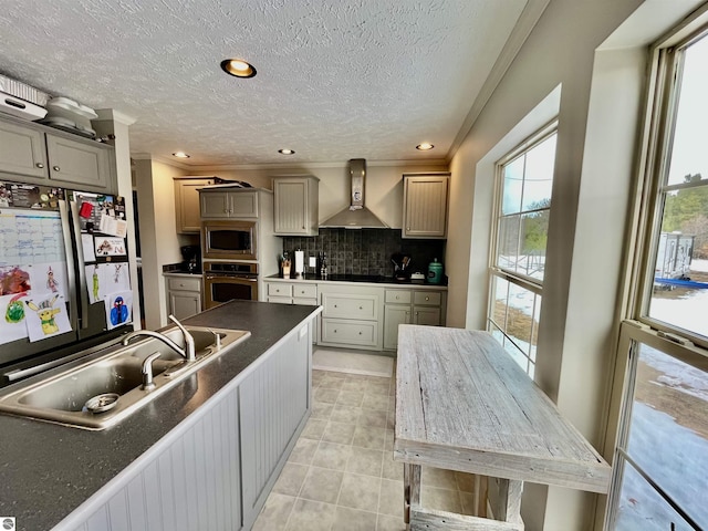 kitchen with sink, wall chimney exhaust hood, stainless steel appliances, backsplash, and gray cabinets