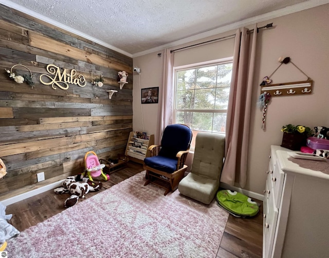 living area featuring dark hardwood / wood-style floors, wood walls, crown molding, and a textured ceiling