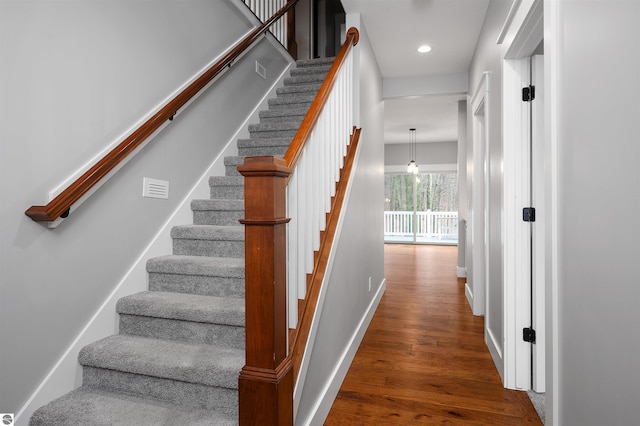 staircase with hardwood / wood-style floors