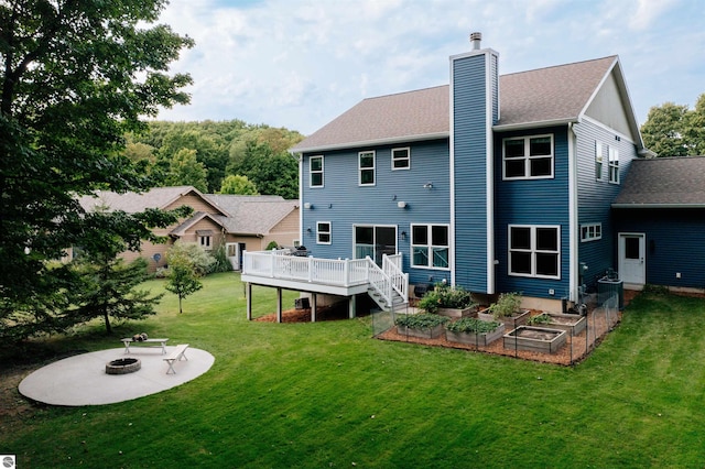 rear view of house with a yard, a fire pit, central AC unit, and a wooden deck