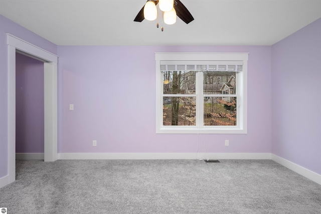 carpeted spare room with ceiling fan