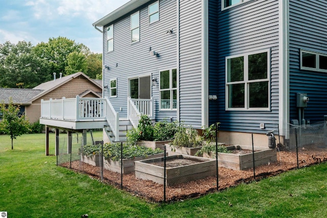 rear view of property with a deck and a lawn