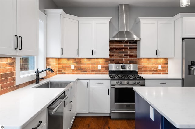 kitchen with white cabinetry, sink, wall chimney range hood, decorative backsplash, and appliances with stainless steel finishes