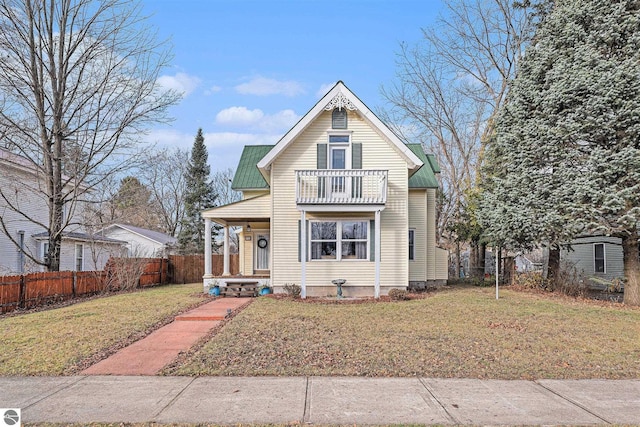 view of front of house featuring a balcony, covered porch, and a front yard