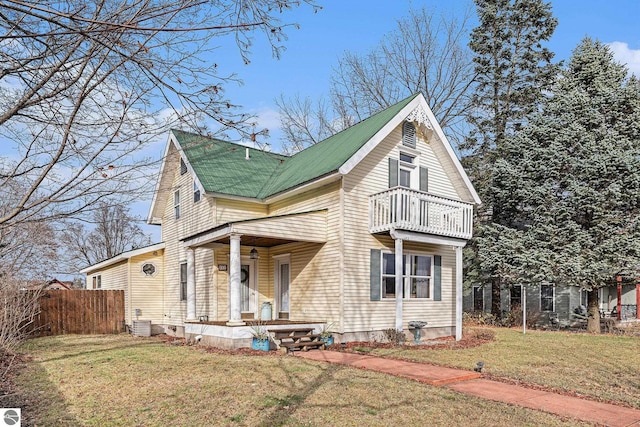 view of front of house with a balcony, a front lawn, and cooling unit