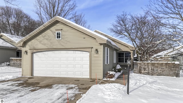 view of snow covered exterior featuring a garage