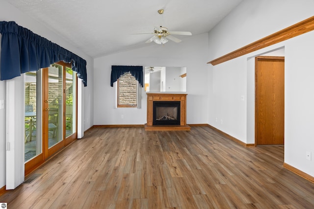 unfurnished living room featuring light wood-type flooring, vaulted ceiling, and ceiling fan