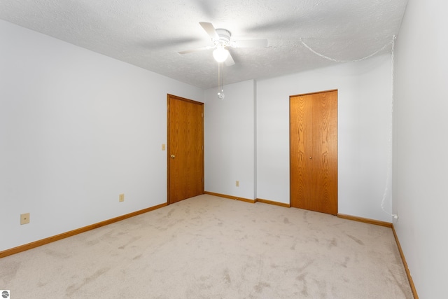 carpeted spare room with ceiling fan and a textured ceiling