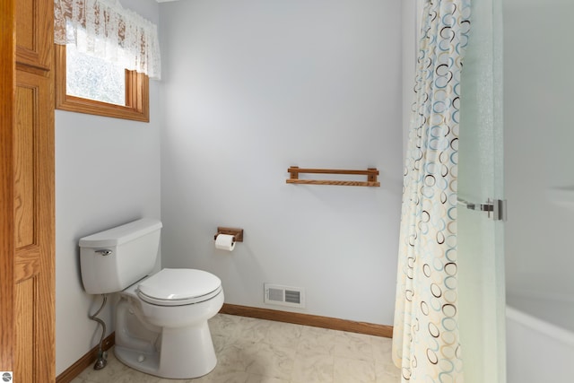 bathroom featuring a shower with shower curtain and toilet