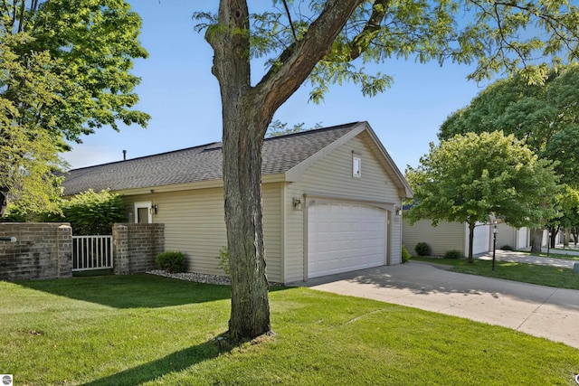 view of side of property featuring a garage and a yard