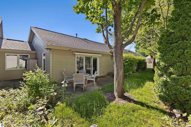 rear view of house featuring a yard and a patio