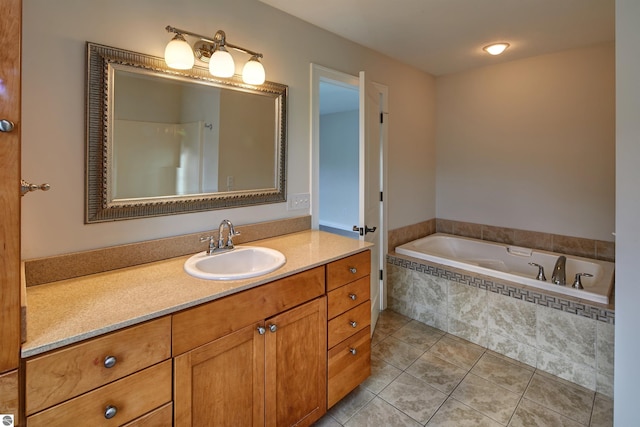 bathroom featuring tile patterned flooring, vanity, and tiled bath