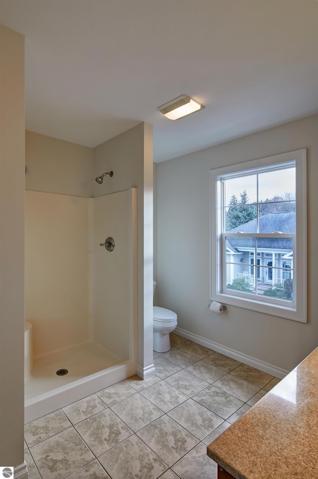 bathroom with tile patterned flooring, toilet, and a shower