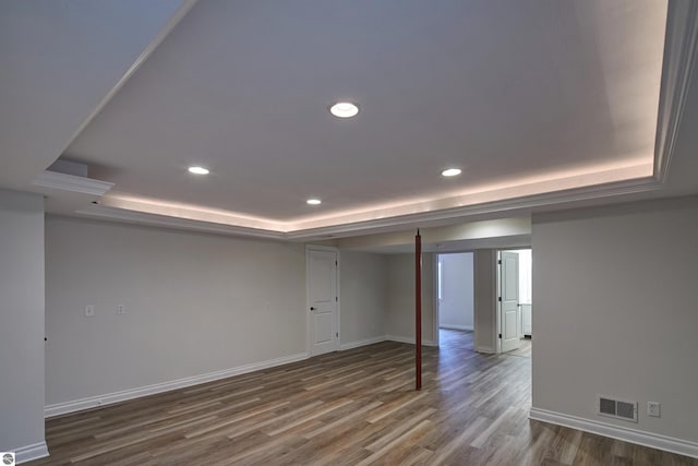 spare room with hardwood / wood-style flooring and a raised ceiling