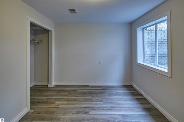 unfurnished bedroom with a closet and dark hardwood / wood-style floors