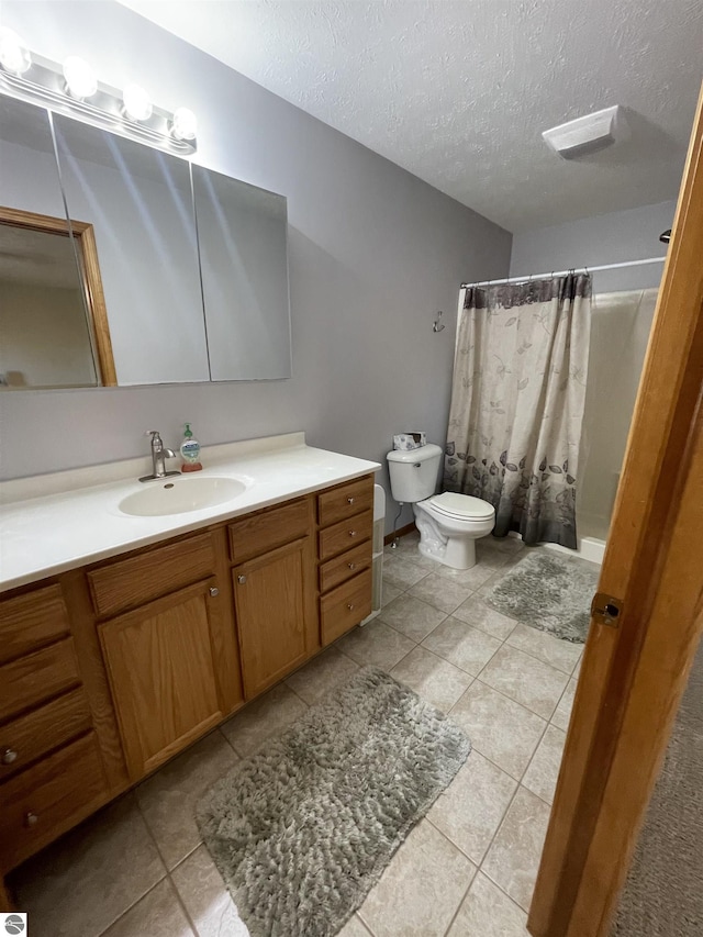 bathroom featuring curtained shower, tile patterned floors, a textured ceiling, toilet, and vanity