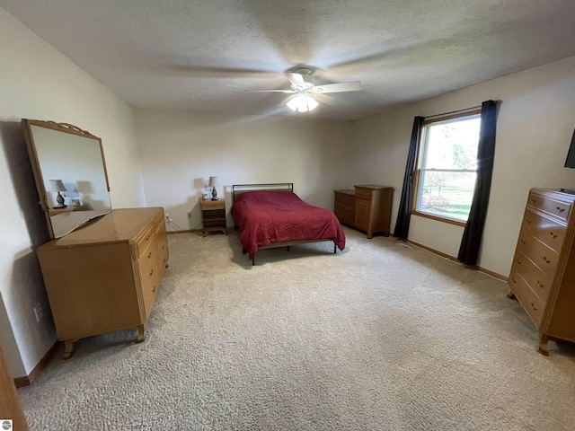 bedroom with a textured ceiling, light colored carpet, and ceiling fan