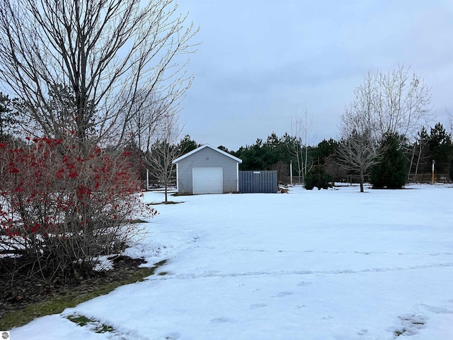 snowy yard with an outdoor structure and a garage