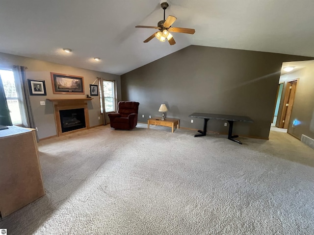 sitting room with plenty of natural light, light colored carpet, and vaulted ceiling